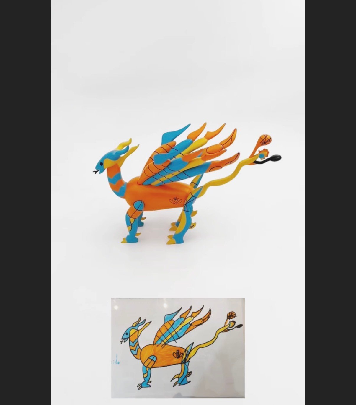 A hand-painted orange and blue dragon figurine beside the original marker drawing