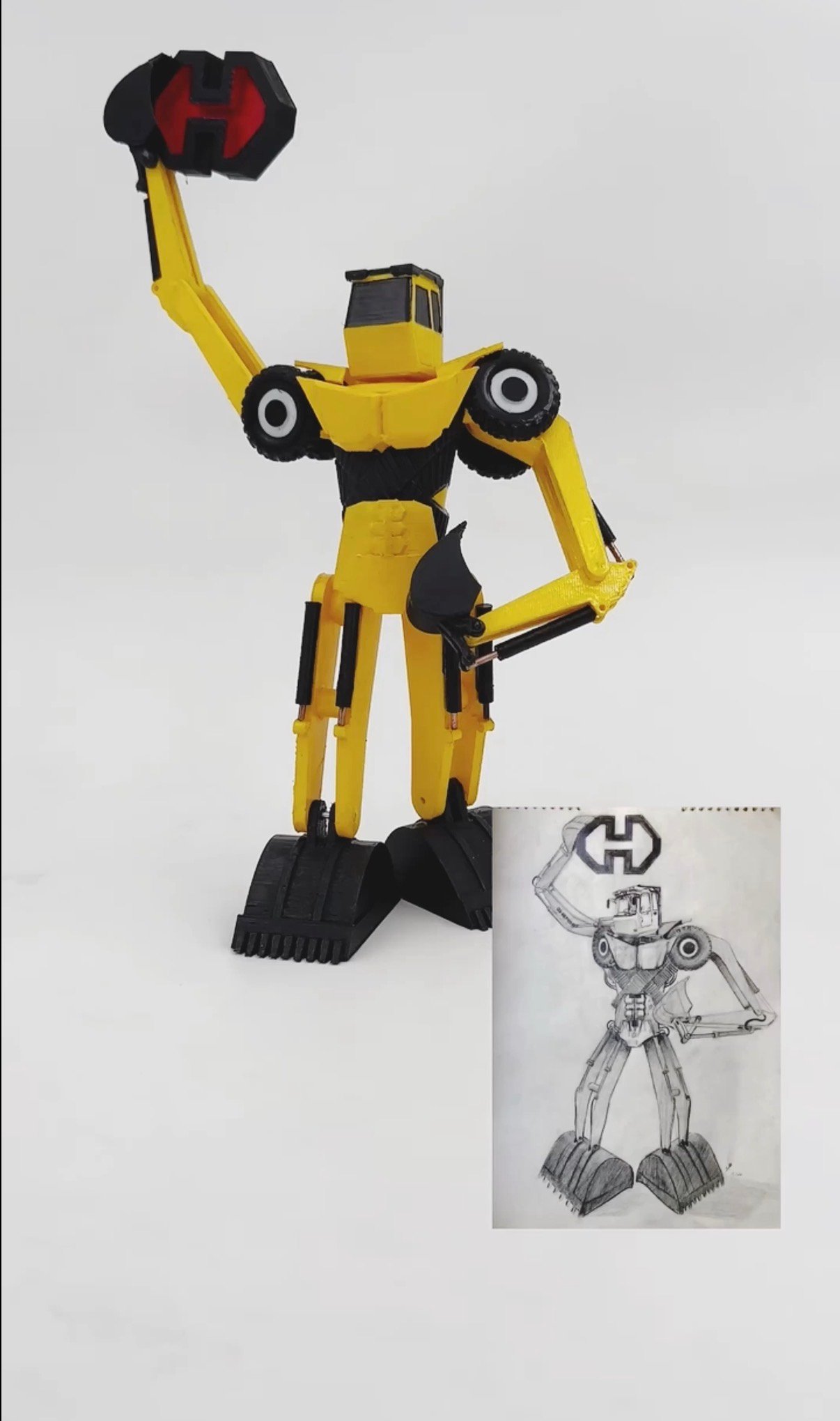A yellow excavator robot figurine beside the original graphite sketch