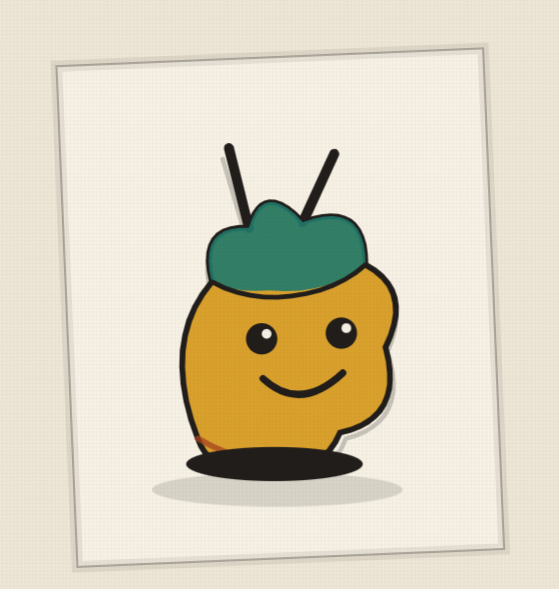 A hand-painted mascot figurine with a green cap and antennae, propped in front of a framed drawing